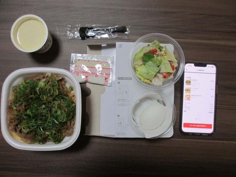 届いた全商品と出前館アプリの注文履歴画面を一緒に撮影した画像